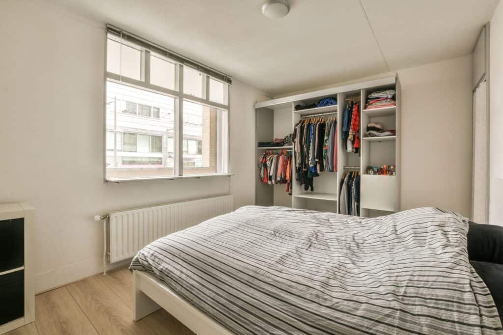 A bedroom with a neat closet