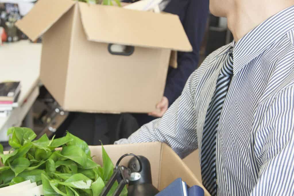 Two employees holding cardboard boxes in the concept of office relocation