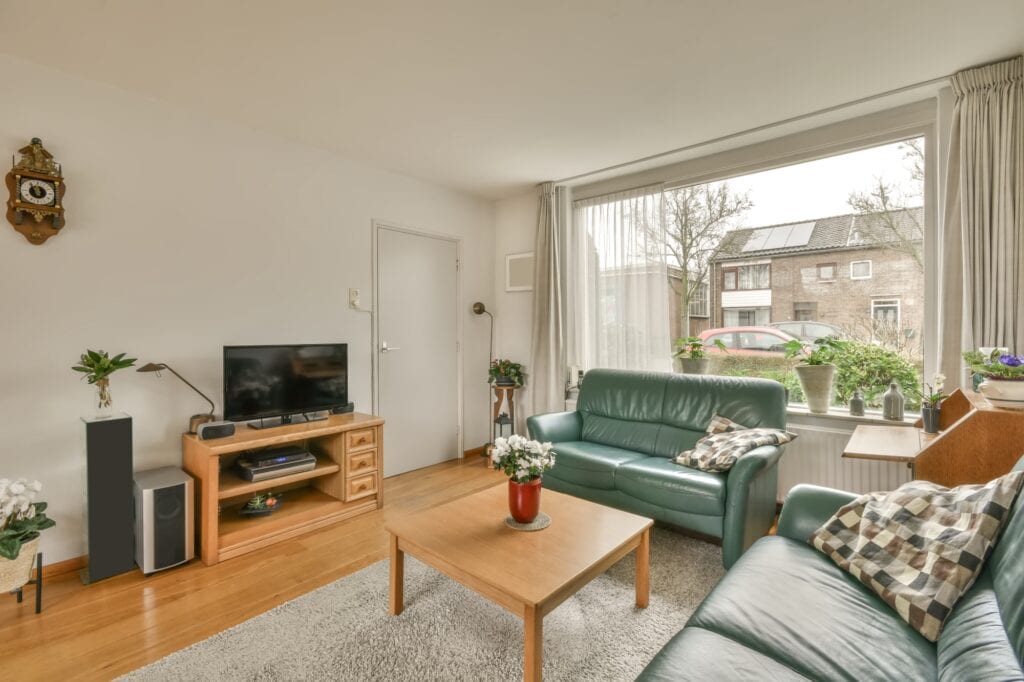 The interior of a living room with pieces of furniture and a huge window